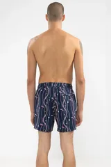 Short de baño azul marino con estampado de cadenas doradas, charms y libélulas en rosa.