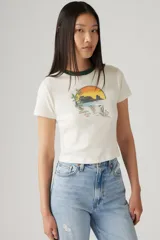 Remera blanca de algodón con cuello redondo ribeteado en verde y estampa de paisaje con sol en tonos naranja, verde y marrón.