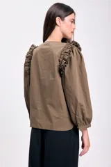 Blusa color verde militar con cuello redondo, abotonada al frente y mangas largas abullonadas con volados en los hombros.