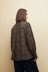 Camisa marrón con estampado animal print, cuello clásico, abotonadura frontal y mangas largas con puños elastizados.