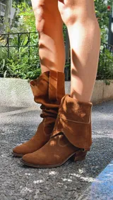 Botas de cuero color marrón, de caña alta y estilo cowboy.