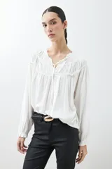 Blusa blanca de estilo boho con escote con volados y lazos, mangas largas abullonadas con puños elásticos.