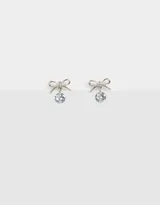 Aros pasantes plateados con dije de moño y strass colgante.