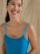 Malla enteriza azul con escote redondo y breteles con diseño a rayas horizontales en celeste y verde.