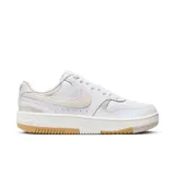 Championes urbanos Nike Gamma Force de mujer, color blanco con detalles en beige y suela con detalles en color caramelo. Presentan el logo de Nike en beige en los laterales.