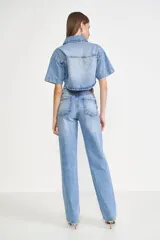 Pantalón de jean celeste de corte recto, tiro alto y con roturas en las rodillas.