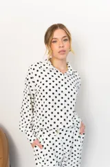 Camisa negra con estampado de lunares blancos, de manga larga y cuello clásico.
