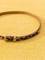 Cinturón delgado de cuero con estampado animal print y hebilla metálica dorada.