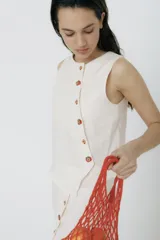 Top sin mangas color fucsia de lino, con cartera asimétrica y botones de madera. Tiene ojales bordados con forma de frutas.