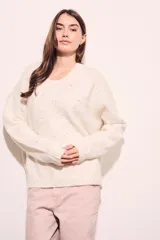 Sweater oversize color crema con textura ligera y detalles en varios colores.