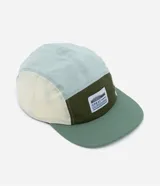 Gorra de microfibra de cinco paneles con visera plana, recortes de colores en contraste, etiqueta frontal con logo y ajuste trasero con velcro.