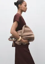 Pantalón de vestir de tiro medio, color marrón oscuro, con efecto arrugado en la tela satinada. Presenta un diseño recto, pinzas delanteras y cierre oculto.