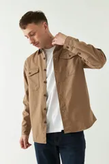 Sobrecamisa color marrón claro de twill de algodón, con cuello clásico, cierre frontal abotonado, dos bolsillos de parche con solapa abotonada en el pecho, mangas largas con puños abotonados y corte regular.