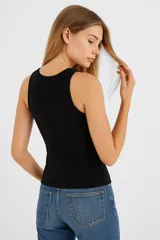 Musculosa blanca de algodón con breteles anchos, corte al cuerpo y cuello redondo.