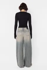 Pantalón denim celeste con efecto lavado, corte wide leg y tiro medio.