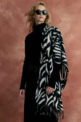 Bufanda larga con estampado de cebra en blanco y negro, terminada en flecos.