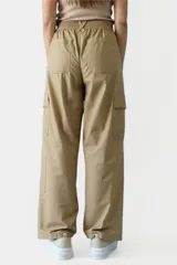 Pantalón negro de tiro alto, corte palazzo y bolsillos laterales.