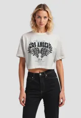 Remera cropped de algodón color crudo, con cuello redondo y estampado frontal con texto 'Los Angeles' y alas.
