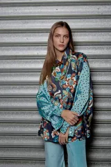 Camisa holgada estampada con motivos paisley en tonos marrón, beige y azul. Tiene cuello solapa, mangas largas y cierre frontal con botones.