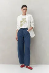 Remera blanca de manga corta con estampado floral en tonos dorados en el frente.