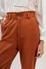Pantalón baggy color ladrillo, de corte sastrero, con cintura alta elastizada y bolsillos laterales.