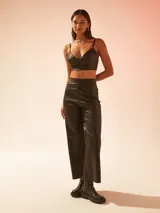 Pantalón negro de cuero sintético, corte recto y tiro alto.