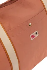 Bolso negro tipo tote con asas de hombro de cinta blanca. Tiene un bolsillo externo con botón a presión y cierre superior con cremallera.