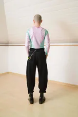 Pantalón negro con detalles de costura visible, corte holgado y puños ajustables.