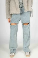 Pantalón de jean celeste de corte wide leg con roturas en las rodillas y apliques de strass.