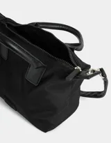 Cartera mini city color negro con doble asa corta de mano, correa regulable ajustable, cierre superior y tag de goma.