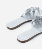 Sandalia plana mule metalizada con puntera cuadrada y tiras cruzadas con efecto crepitante.