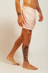 Short de baño blanco con estampado de hojas en tonos celeste y naranja, con cordón ajustable en la cintura.