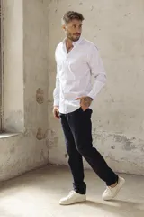 Camisa blanca de corte slim fit, manga larga y cuello clásico. Cierre frontal con botones.