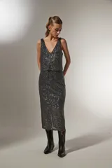 Falda midi dorada con lentejuelas y abertura lateral.