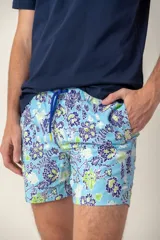 Short de baño azul con estampado de flores blancas, cintura elástica y cordón ajustable.