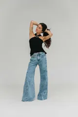 Blusa blanca de crepe twill con cuello halter y detalle de hebilla dorada en el escote.