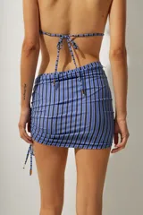 Minifalda de playa con estampado a rayas verticales azules y negras, con cordones laterales ajustables.