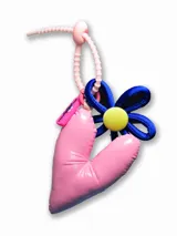 Llavero con dije de corazón acolchado rosa, flor azul con centro amarillo y cinta de agarre rosa.