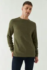 Sweater azul de punto con cuello redondo, mangas largas y logo bordado en el pecho. Corte slim fit.