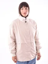 Campera color beige con cuello de piel sintética blanca, cierre frontal con cremallera y bolsillos laterales.