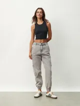 Pantalón jean gris de corte recto, con bolsillos laterales y tobillos ajustados con elástico.