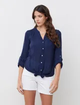 Blusa de gasa color coral con escote en V, abertura central con botones y manga regulable.