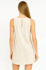 Vestido corto color beige, sin mangas y con cuello redondo.