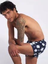 Bóxer de algodón con estampado floral en tonos azul y blanco, con cintura elástica y logo de la marca en el centro.