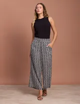 Pantalón capri estampado con flores en tonos celeste, blanco y negro. Tiene pretina elastizada en la parte trasera y bolsillos delanteros.