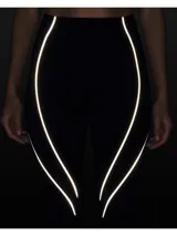 Calza deportiva negra con detalles de líneas plateadas a los costados.