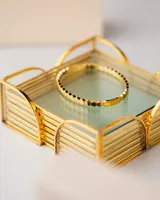 Pulsera rígida de acero quirúrgico con baño de oro 18k, formada por eslabones hexagonales.