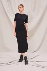 Falda midi negra de viscosa, poliéster y elastano, con corte recto y paneles con costuras a la vista.