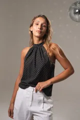 Musculosa negra con lunares blancos, cuello halter y botón en la parte trasera del cuello.