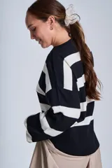 Sweater tejido a rayas horizontales anchas color crudo y negro, con cuello redondo y mangas largas.